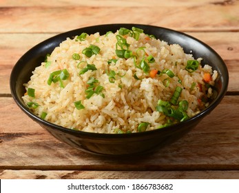 Healthy and tasty veg fried rice made of mixed veggies served in bowl over a rustic wooden background, Indo chinese, Indian cuisine, selective focus