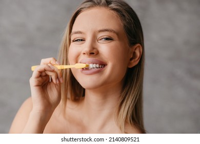 Healthy teeth and care. Happy lady brushing teeth with toothbrush and smiling at camera in bathroom interior in the morning, closeup, free space - Shutterstock ID 2140809521