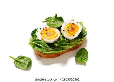 Healthy Toast With Sliced Avocado, Boiled Eggs, Spices And Fresh Spinach. Delicious Breakfast Or Snack Isolated On White Background