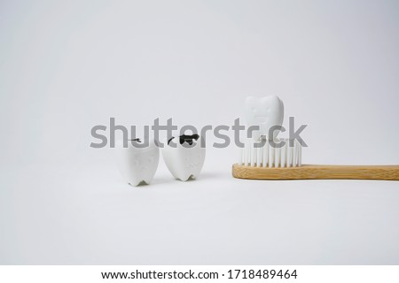 Healthy Tooth on Wooden Brown Toothbrush with Cavity and Decayed Tooth on White Background, If Brush Teeth, Teeth will Good Healthy