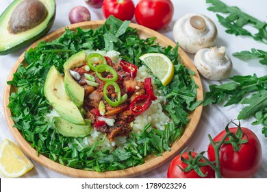 Healthy Trendy Vegan Burrito Bowl With White Rice, Spicy Tomato Mushroom Mix, Green Arugula, Lemon And Sliced Avocado. Topped With Red And Green Chili Peppers And Scallions