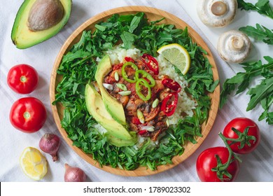 Healthy Trendy Vegan Burrito Bowl With White Rice, Spicy Tomato Mushroom Mix, Green Arugula, Lemon And Sliced Avocado. Topped With Red And Green Chili Peppers And Scallions