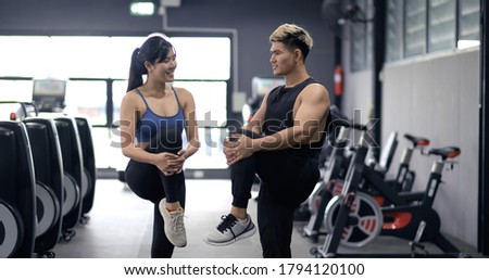 Healthy two people young asian doing stretching leg after workout at fitness gym, Cooldown muscle healthy together, sporty couple teamwork and partner bodybuilding lifestyle concept.