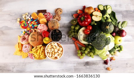 healthy or unhealthy food. Concept photo of healthy and unhealthy food. Fruits and vegetables vs donuts,sweets and burgers on table