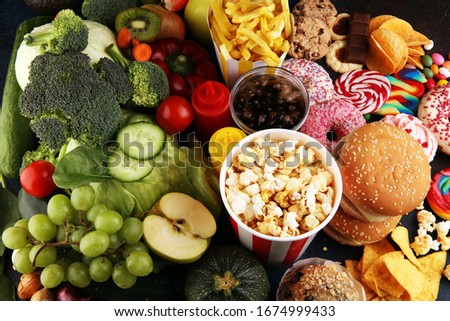 healthy or unhealthy food. Concept photo of healthy and unhealthy food. Fruits and vegetables vs donuts,sweets and burgers on table