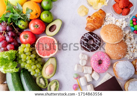Healthy and unhealthy food concept. Top view of fast and sweet food vs fruit and vegetables