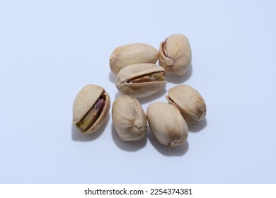 Healthy unshelled pistachio nuts photographed against a white background - Shutterstock ID 2254374381