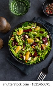 Healthy Vegan Avocado, Orange And Beet Salad In Black Bowl, Dark Background, Top View