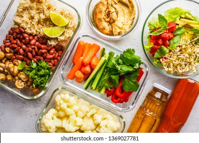 Healthy Vegan Food In Glass Containers, Top View. Rice, Beans, Vegetables, Hummus And Juice For Take-away Lunch