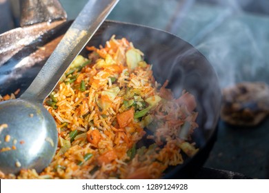 Healthy Vegan Food - Vegetable Pilaf Or Biryani From Indian Cuisine, Close Up. Cooking Vegetable Biryani In An Street Cafe On A Local Market In India.