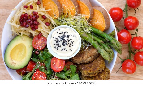 Healthy Vegan Lunch Bowl. Avocado, Chickpea Patties, Yams, Asparagus, Tomato, Vegetable Salad. Top View. 