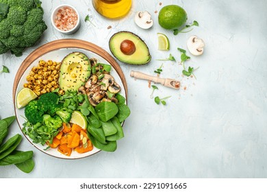 healthy vegan lunch bowl with Avocado, mushrooms, broccoli, spinach, chickpeas, pumpkin on a light background. vegetables salad. Top view. - Shutterstock ID 2291091665