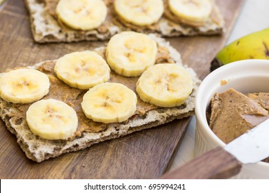 Healthy vegan snack with scandinavian rye crispbread, homemade peanut butter and slices of Canary island bananas