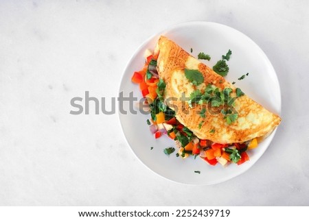 Healthy vegetable loaded omelette. Top view on a plate over a white marble background. Stockfoto © 