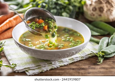 Healthy vegetable soup from fresh spring vegetables. Scooping up hot soup with a ladle. - Powered by Shutterstock