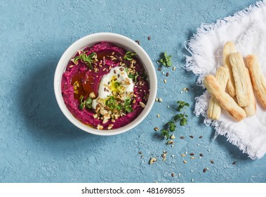Healthy vegetarian beet hummus and puff pastry bread sticks on a blue background. Healthy snack