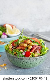 Healthy Vegetarian Chickpea Salad in a bowl with vegetables, herbs and dressing on a blue background. Healthy food concept, A dish of oriental cuisine. - Shutterstock ID 2100490441