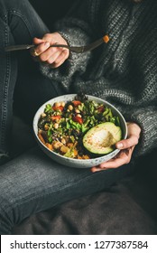 Healthy Vegetarian Dinner. Woman In Jeans And Warm Sweater Holding Buddha Bowl With Fresh Salad, Avocado Half, Grains, Beans, Roasted Vegetables. Superfood, Vegan, Clean Eating, Dieting Food Concept