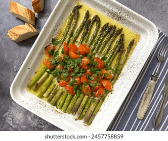 Healthy, vegetarian dish, green asparagus with cherry tomatoes, garlic, salt, pepper, olive oil and parmesan, baked in the oven at 180 degrees for about 20 minutes. - Powered by Shutterstock