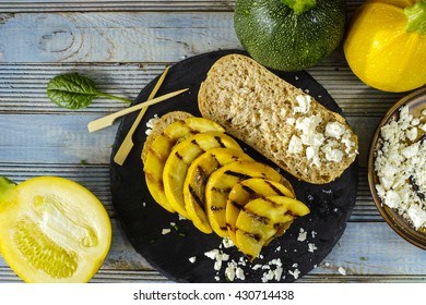 Healthy Vegetarian Veggie Sandwich With  Grilled Yellow Squash Zuccihi, Mushrooms, Paprika, Salad, Feta Cheese On Blue Table Top