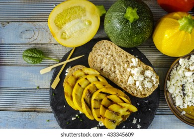 Healthy Vegetarian Veggie Sandwich With  Grilled Yellow Squash Zucchini, Mushrooms, Paprika, Salad, Feta Cheese On Blue Table Top