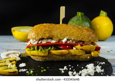 Healthy Vegetarian Veggie Sandwich With  Grilled Yellow Squash Zucchini, Mushrooms, Paprika, Salad, Feta Cheese On Blue Table Top