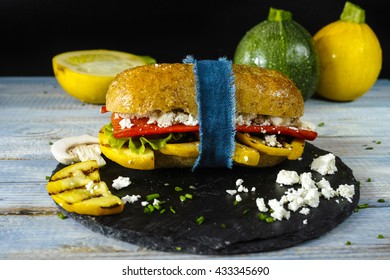 Healthy Vegetarian Veggie Sandwich With  Grilled Yellow Squash Zucchini, Mushrooms, Paprika, Salad, Feta Cheese On Blue Table Top