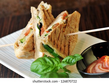 Healthy veggie panini sandwiches, Freshly grilled panini with olives, basil leaves, fresh red and green peppers, tomatoes, and mozzarella cheese served on ciabatta bread with cream ketchup sauce