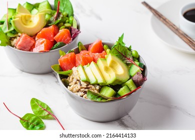 Healthy Version Of Hawaiian Poke - Brown Rice, Salmon, Edamame, Cucumber And Avocado In A Gray Bowl, Marble Background. Fish Fresh Salad For A Healthy Diet.