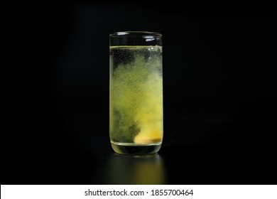 Healthy Vitamin Tablet Bubbling In Glass Of Water,isolated On A Black Background.