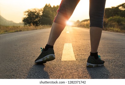 Healthy way of life concept, goals and plans, Healthcare and medical. Woman in sports wear running start to goals on the road in sunset background.