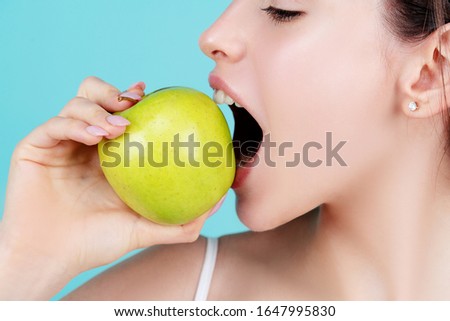 Healthy white theeth. Woman with strong teeth. Dental care and teeth whitening. Close-up of perfect smile with green apple