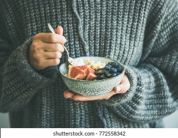 Healthy Winter Breakfast. Woman In Grey Woolen Sweater Eating Rice Coconut Porridge With Figs, Berries And Hazelnuts. Clean Eating, Vegetarian, Vegan, Alkiline Diet Food Concept