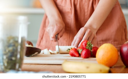 Healthy woman cutting fruit to make a smoothie with nutrition for an organic diet at home. Closeup of caucasian female hands chopping fresh produce for a health drink in a kitchen. - Powered by Shutterstock