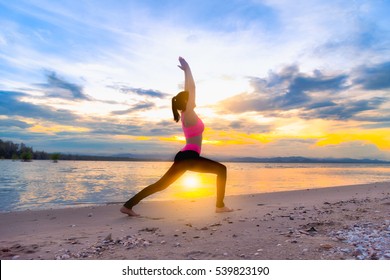 Healthy woman doing Yoga exercises on the beach in sunset time, Thailand