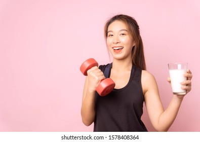 Healthy Woman Fitness Drinking Milk And Holding Red Dumbbell For Health Diet At Fitness Gym Sport,smile Cheerful,happy,exercise Lifestyle Young Sport Girl Concept,portrait Pink  Background,copy Space