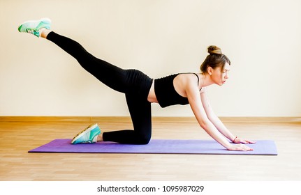 Healthy woman fitness mat doing warmup exercise. Fit woman sitting on exercise mat stretching.