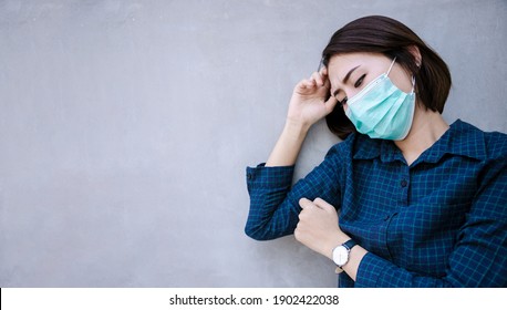 Healthy woman in green medical protective mask showing gesture stop. Health protection and prevention during flu and infectious outbreak or Covid-19 at congrete wall 