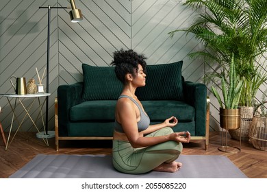Healthy woman meditating in the living room - Powered by Shutterstock