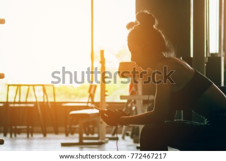 Healthy woman relaxing after exercise and  listen music after the workout.