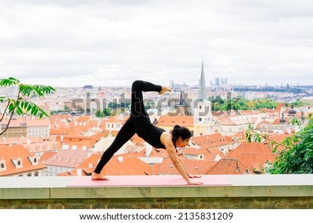 Healthy woman in a sportswear practicing yoga outdoor, doing exercise, full length portrait.
