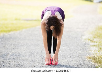 Healthy Woman Stretching And Touching Her Toes