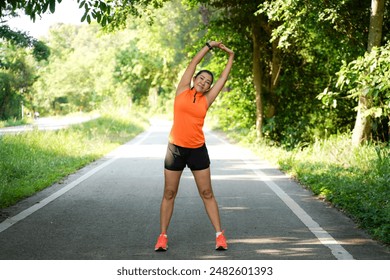 Healthy woman warming up stretching her arms. Asian runner woman workout before fitness and jogging session on the road nature park. Healthy and Lifestyle Concept
 - Powered by Shutterstock