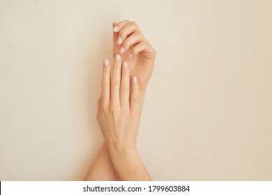 Healthy Woman's Hands On Neutral Background.  Nude Nails. Clean Skin. Soft Light. Good For Cosmetics. Natural Colors, Retouch. Long Elegant Fingers. Spa, Medicine Advertisement. Skin Care. Beauty.