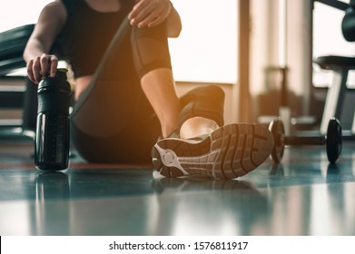 Healthy women are sitting and relaxing after exercising with whey protein after workouts at the indoor gym. - Shutterstock ID 1576811917