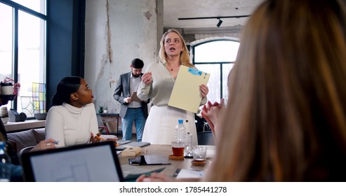 Healthy Workplace Concept. Successful Young Blonde Female Boss Leading Team Seminar At Modern Loft Office Slow Motion.