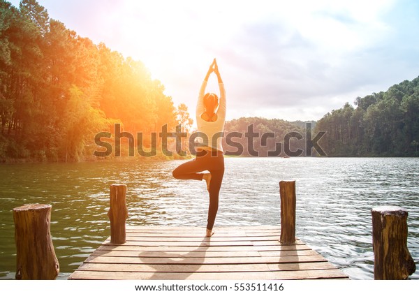 Healthy Yoga woman lifestyle balanced\
practicing meditate and energy yoga on the bridge in morning and\
sunset outdoors nature. Healthy life\
Concept\
