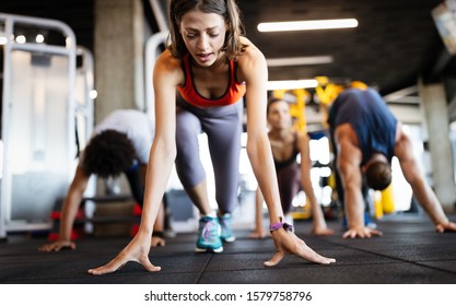 Healthy Young Athletes Friends Doing Exercises At Gym.