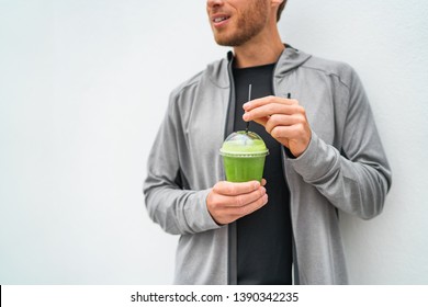 Healthy young man drinking green juice smoothie cup as weight loss detox meal replacement diet. Spinach protein shake for morning breakfast. - Powered by Shutterstock