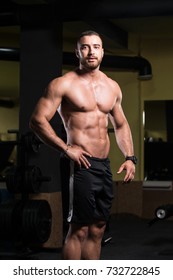 Healthy Young Man Standing Strong In The Gym And Flexing Muscles - Muscular Athletic Bodybuilder Fitness Model Posing After Exercises - Shutterstock ID 732722845